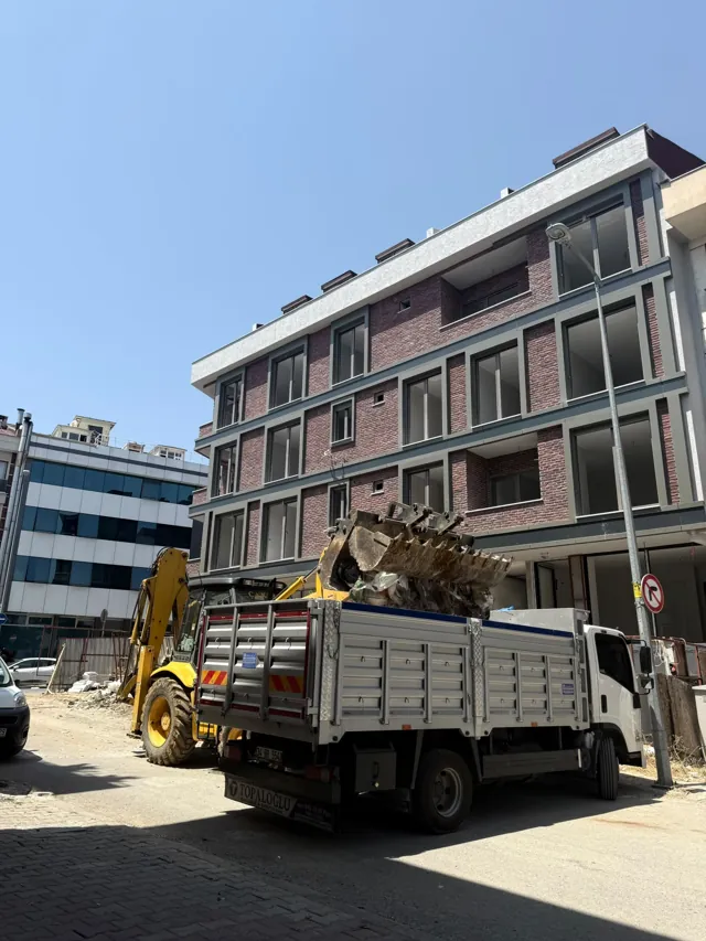 İnşaat sahasında kamyona iş makinesiyle moloz yüklenmesi